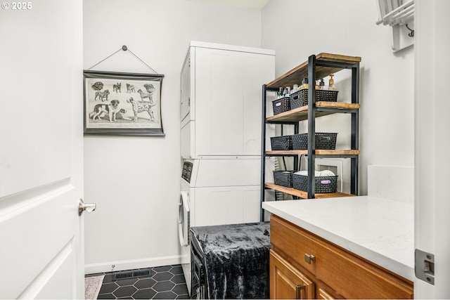 interior space featuring stacked washer / dryer, visible vents, and baseboards