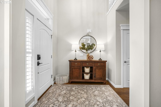 foyer entrance with baseboards and wood finished floors