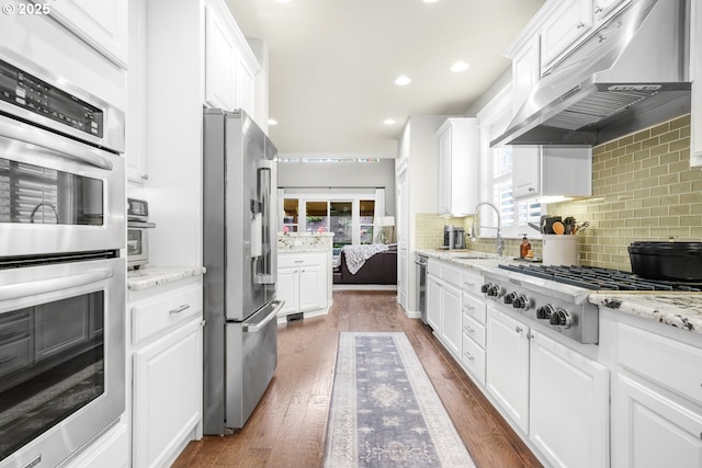 kitchen featuring appliances with stainless steel finishes, white cabinets, and under cabinet range hood