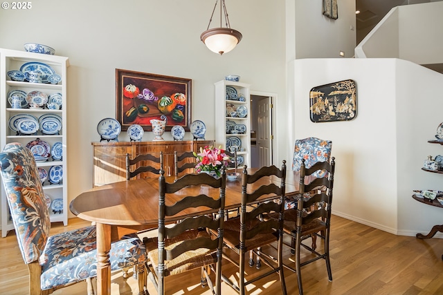 dining room featuring hardwood / wood-style flooring and a high ceiling