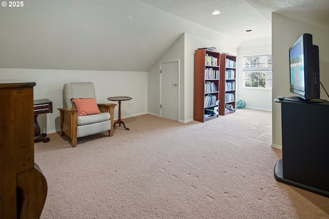 living area with lofted ceiling, light carpet, and a textured ceiling