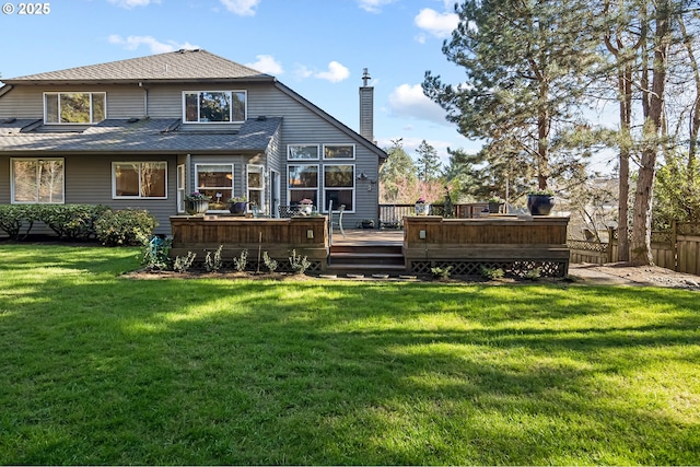 back of property featuring a wooden deck and a yard