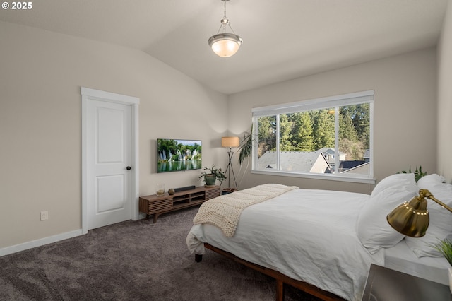 bedroom with lofted ceiling, baseboards, and dark colored carpet