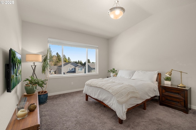 carpeted bedroom with lofted ceiling and baseboards