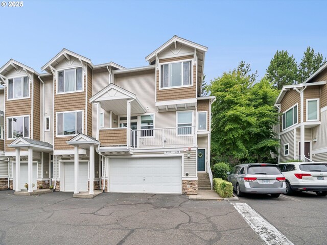 8710 SW 147th Ter Unit 104, Beaverton, OR 97007 - view of property featuring stone siding, a garage, and driveway