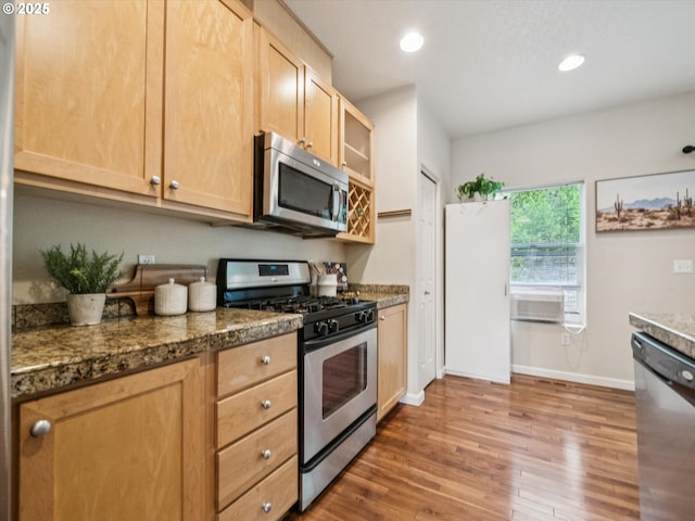 8710 SW 147th Ter Unit 104, Beaverton, OR 97007 - kitchen with stainless steel appliances, light brown cabinets, wood finished floors, tile counters, and glass insert cabinets