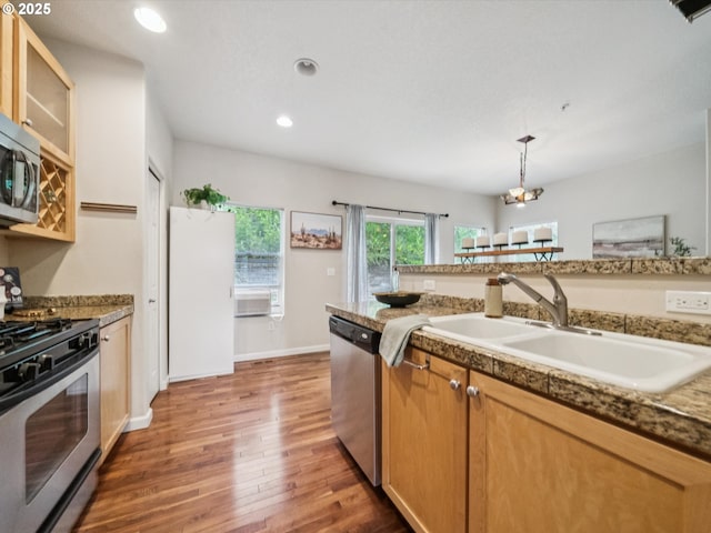 8710 SW 147th Ter Unit 104, Beaverton, OR 97007 - kitchen with stainless steel appliances, wood finished floors, glass insert cabinets, recessed lighting, and pendant lighting