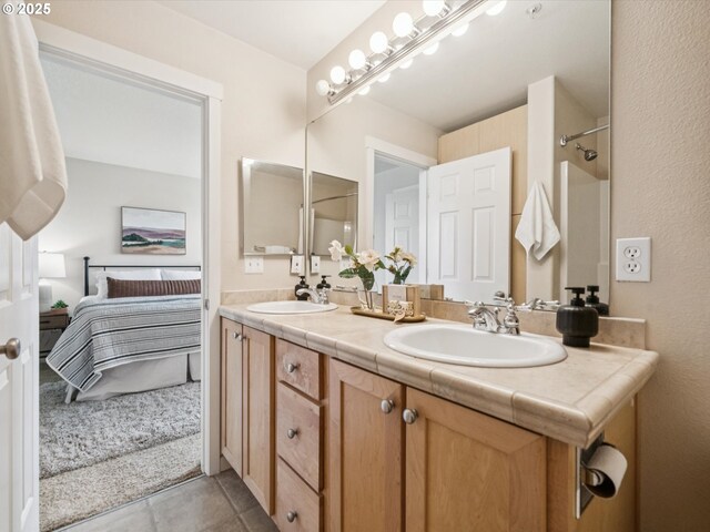 8710 SW 147th Ter Unit 104, Beaverton, OR 97007 - full bathroom featuring ensuite bath, double vanity, a shower, and tile patterned floors