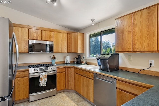 kitchen with stainless steel appliances, lofted ceiling, a sink, and brown cabinetry