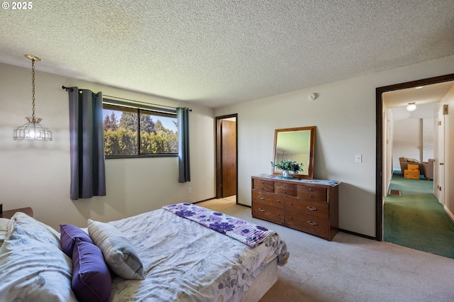 bedroom with light colored carpet and a textured ceiling