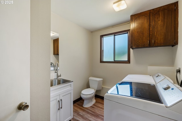 bathroom featuring washer and clothes dryer, a sink, wood finished floors, toilet, and baseboards
