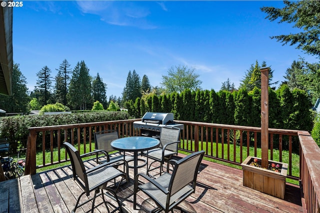 deck featuring outdoor dining area and grilling area