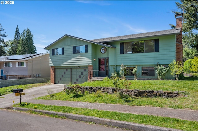 bi-level home with driveway, a garage, and a chimney
