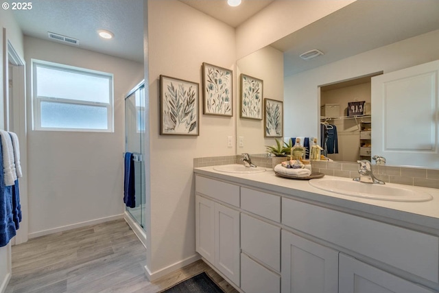 2969 U St, Springfield, OR 97477 - full bath featuring a stall shower, double vanity, wood finished floors, a spacious closet, and baseboards