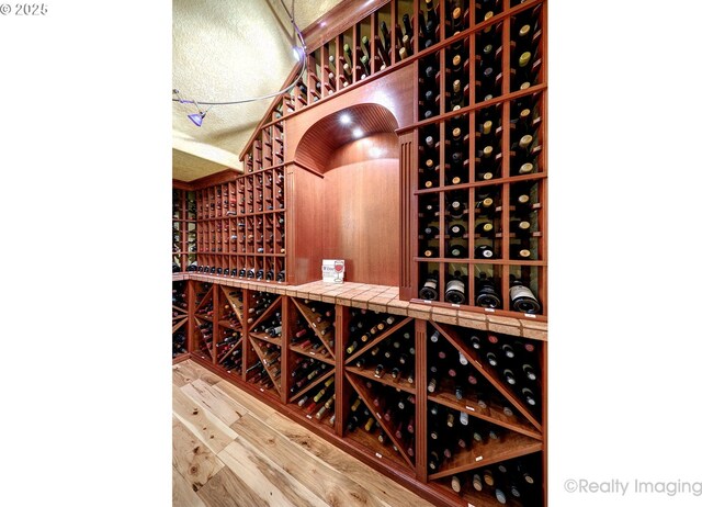 wine room featuring wood finished floors and a textured ceiling