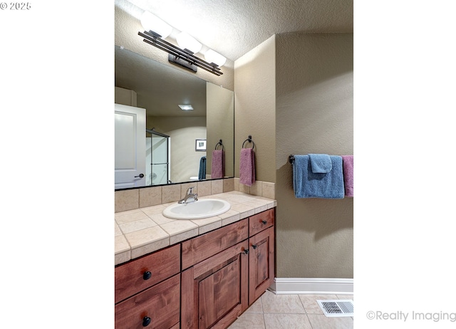 bathroom with vanity, tile patterned flooring, and a textured ceiling