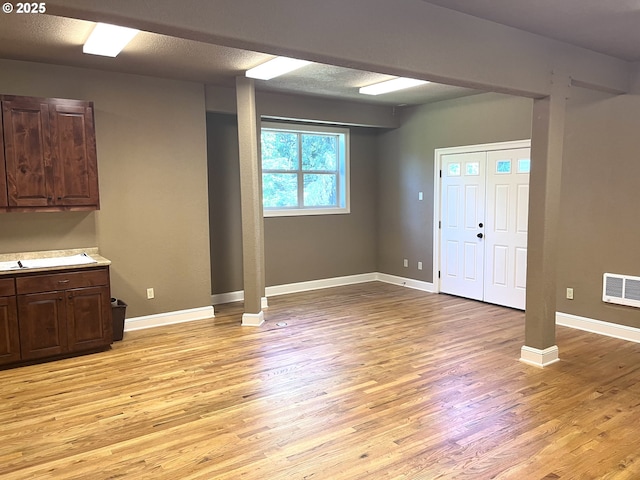 foyer entrance with a textured ceiling and light hardwood / wood-style flooring