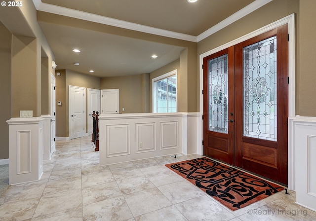 foyer entrance featuring crown molding and french doors