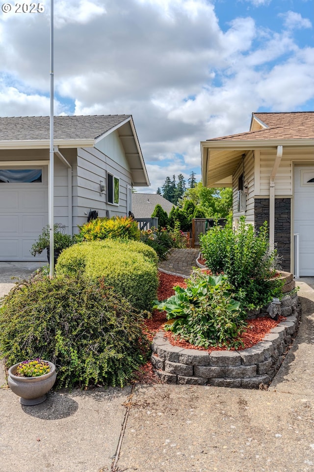 12520 SW Prince Albert St, King City, OR 97224 - view of side of home featuring an attached garage, roof with shingles, and stone siding