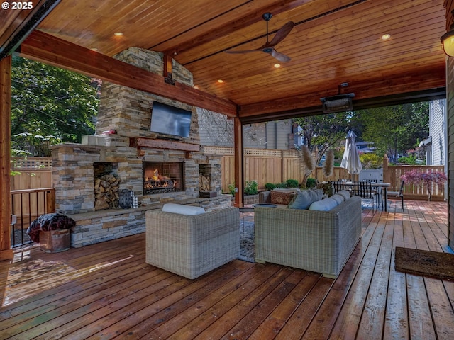 wooden deck featuring outdoor dining area, a fenced backyard, a ceiling fan, and an outdoor living space with a fireplace