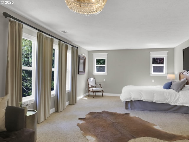 bedroom with baseboards, visible vents, light carpet, and multiple windows