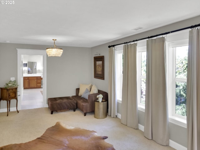 living area featuring an inviting chandelier, light carpet, and a wealth of natural light