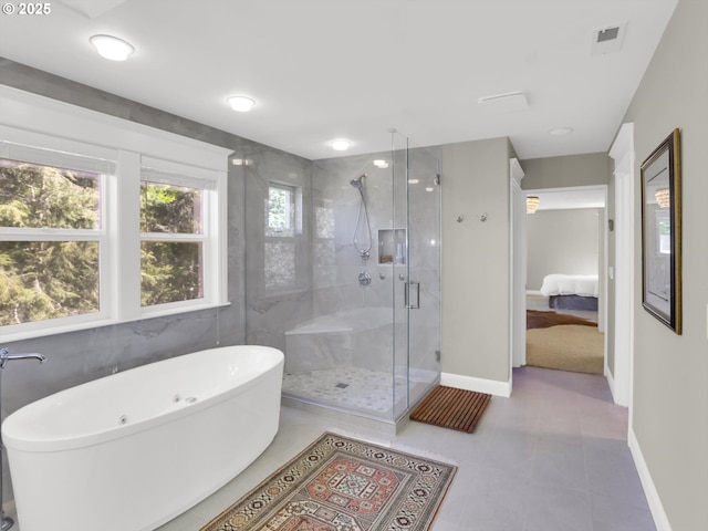 ensuite bathroom with a freestanding tub, baseboards, a shower stall, ensuite bathroom, and visible vents