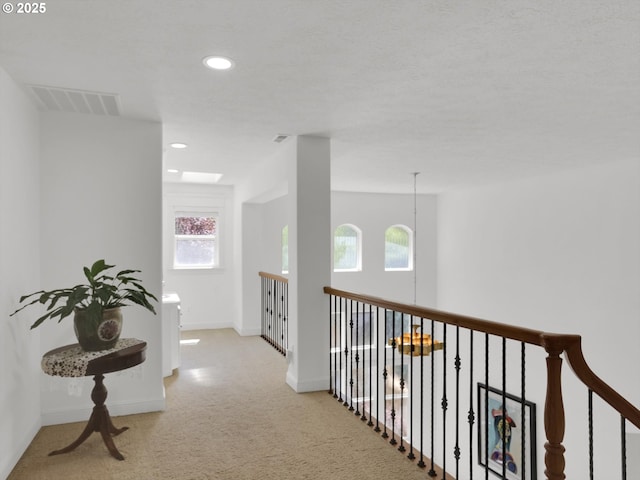 corridor with carpet floors, baseboards, recessed lighting, and visible vents