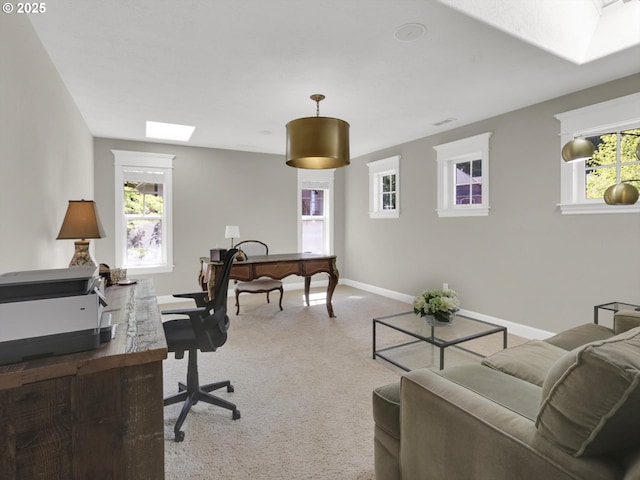 office space with baseboards, light colored carpet, and a skylight
