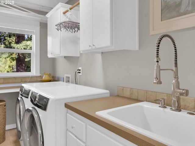 laundry room featuring a sink, cabinet space, light tile patterned floors, and washing machine and clothes dryer