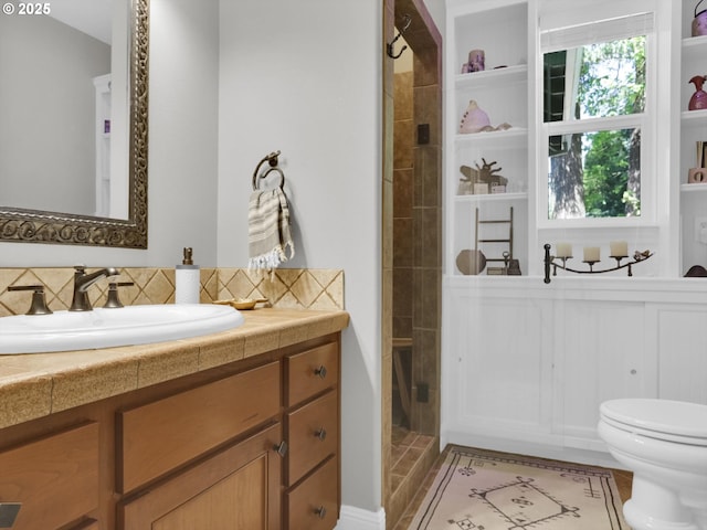 full bath with vanity, decorative backsplash, a stall shower, and toilet