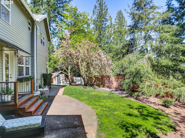 view of yard with a fenced backyard, an outdoor structure, a patio area, and a storage shed