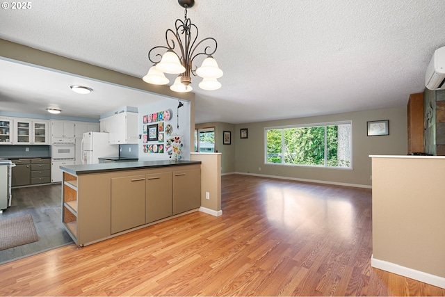 536 Kingswood Ave, Eugene, OR 97405 - kitchen featuring a textured ceiling, dark countertops, light wood-type flooring, baseboards, and white appliances