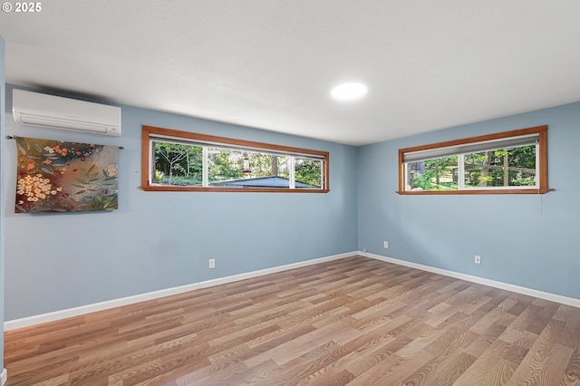 536 Kingswood Ave, Eugene, OR 97405 - unfurnished room featuring baseboards, a wealth of natural light, a wall mounted air conditioner, and wood finished floors