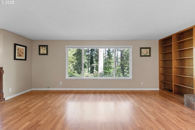 536 Kingswood Ave, Eugene, OR 97405 - unfurnished room featuring built in features, baseboards, light wood-style flooring, and a textured ceiling