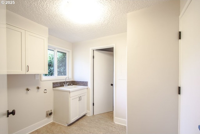 2440 SW Burbank Ave, Portland, OR 97225 - laundry area with a textured ceiling, cabinet space, and light colored carpet