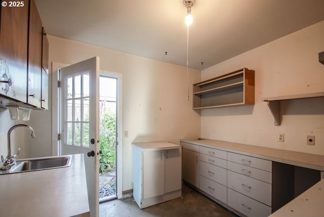 2440 SW Burbank Ave, Portland, OR 97225 - kitchen with open shelves, light countertops, and unfinished concrete flooring