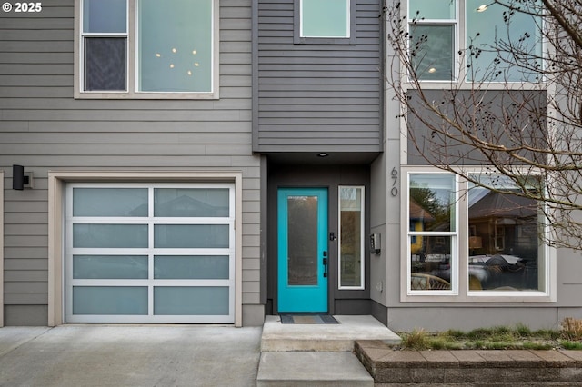 entrance to property with concrete driveway and a garage