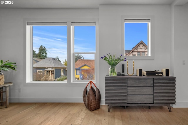 living area with a healthy amount of sunlight, baseboards, and wood finished floors