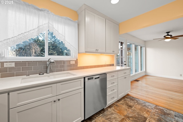 kitchen featuring sink, stainless steel dishwasher, ceiling fan, decorative backsplash, and white cabinets