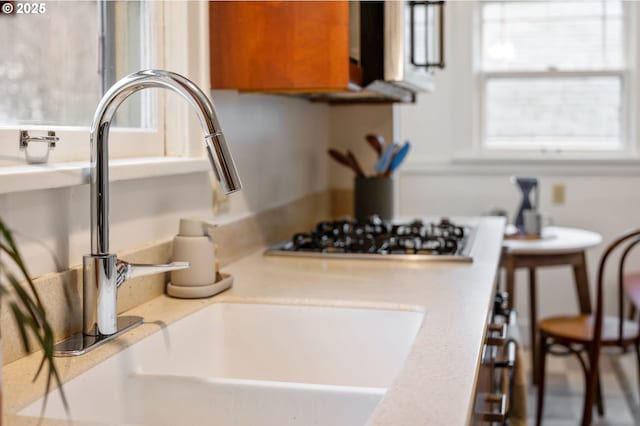 interior details with light countertops, gas stovetop, and a sink