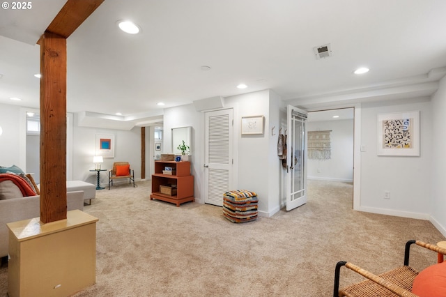 living area with recessed lighting, visible vents, light colored carpet, and baseboards