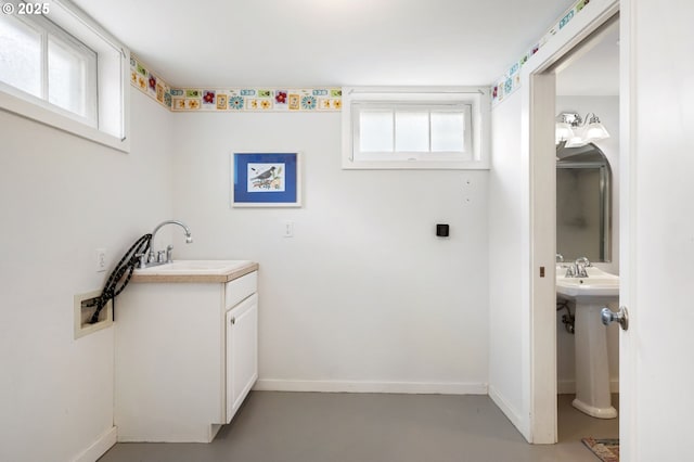 bathroom with baseboards, concrete floors, and a sink