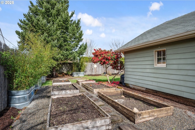 view of yard featuring a vegetable garden and fence