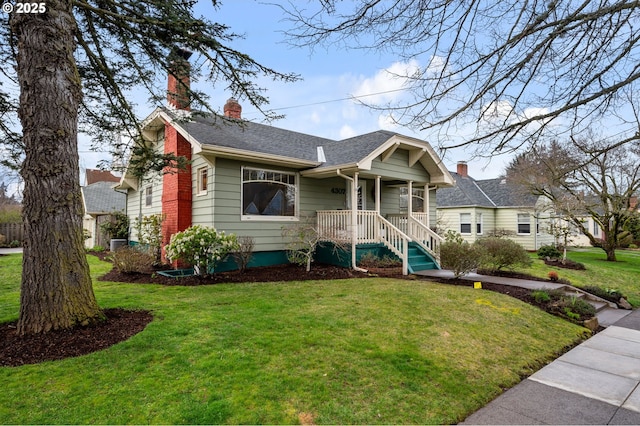 view of front facade featuring a front yard, roof with shingles, and a chimney