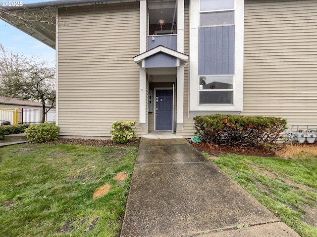 view of exterior entry with a lawn