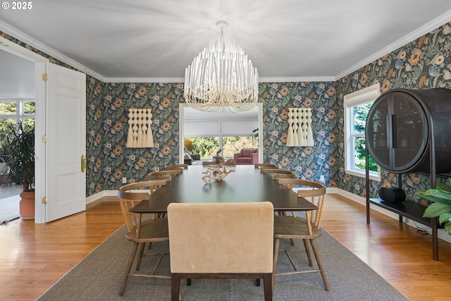 dining room featuring wallpapered walls, wood finished floors, a chandelier, crown molding, and baseboards