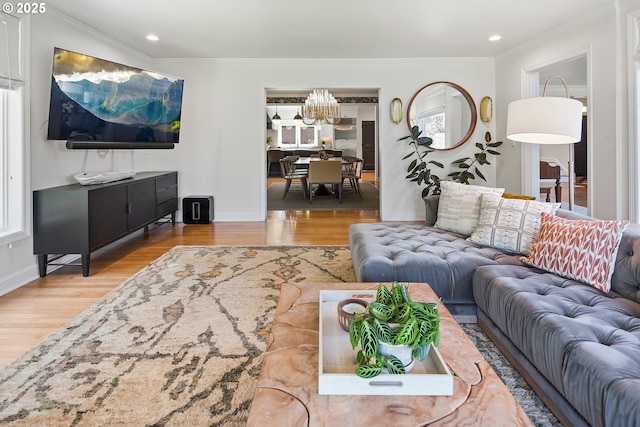 living room with a chandelier, wood finished floors, crown molding, baseboards, and recessed lighting