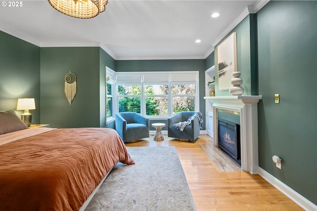 bedroom featuring ornamental molding, wood finished floors, recessed lighting, a high end fireplace, and baseboards
