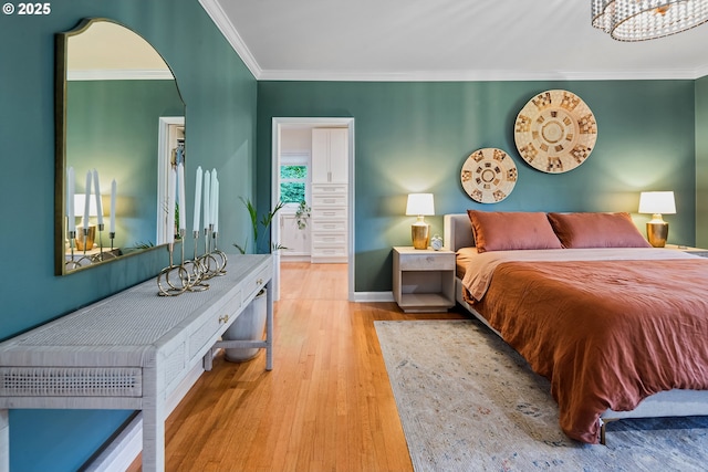 bedroom with wood finished floors, crown molding, arched walkways, and a chandelier